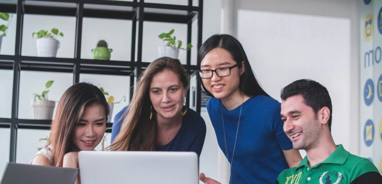 Vier lernende Personen gemeinsam vor einem Laptop
