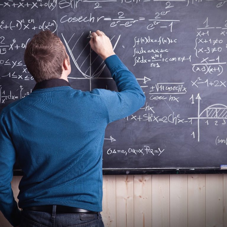 teacher at work, AdobeStock_57450118 von tiero, Standard-Lizenz erworben am 18.12.2020 Mathematikdozent schreibend an einer Kreidetafel